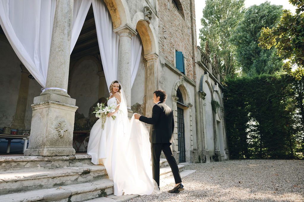 bride and groom walking up the steps of their Italian destination wedding venue